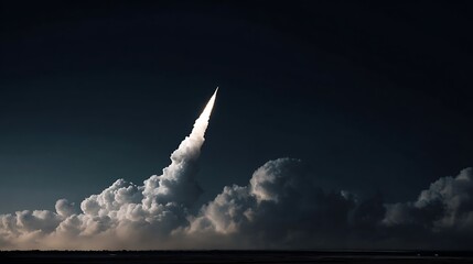 A rocket ascends piercing the dark sky leaving a trail of bright light and billowing clouds during its powerful groundbreaking launch