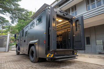 Naklejka premium A modern prison car with the side doors open, revealing the barred chairs inside.