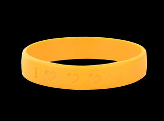 Glossy Yellow Silicone Wristband and carved in the shape of a heart on black background.