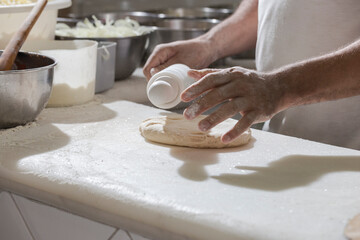 Chef pizzaiolo abrindo massa de pizza com o rolo