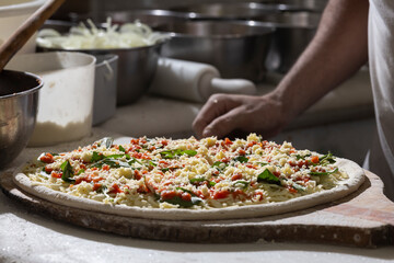 Chef pizzaiolo prepara uma pizza