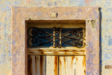 Aged Rustic Door with Distressed Paint and Decorative Metalwork Overhead