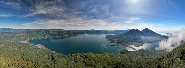 Aerial panoramic view of Lake Atitlán and San Pedro in Guatemala with volcanic mountains, lush...