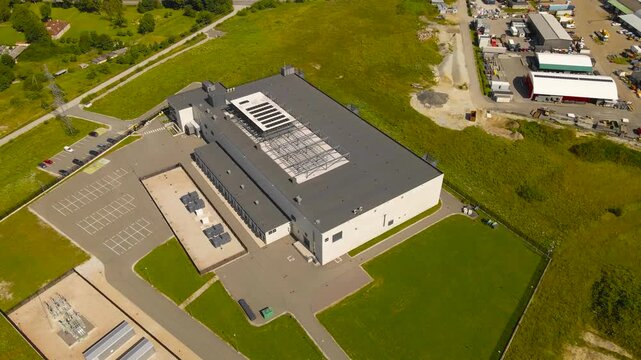 Aerial view of a modern data center in a summer green countryside. For AI, algorithms, intelligent systems, data, cryptography, security and quantum computing. Cooling systems spinning on the rooftop.