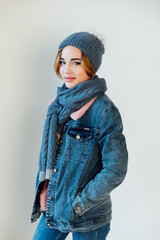 woman in winter clothes and hat smiling on white background