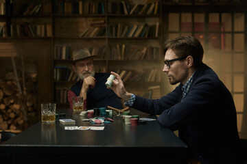 An intense card game between two players in smoky library