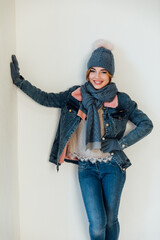 woman in winter clothes and hat smiling on white background