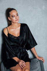 Portrait of a beautiful woman in a black silk robe