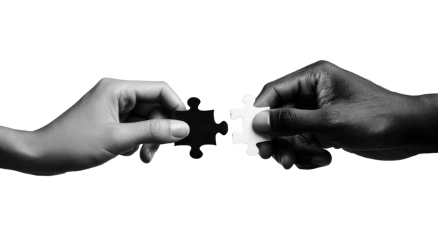 Two hands, one light-toned and one dark-toned, join a jigsaw puzzle piece