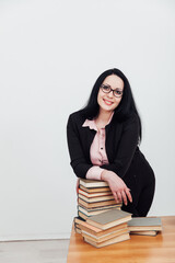 teacher with stacks of books on table