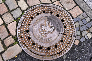 Kanaldeckel mit Friedenstaube in Münster als Erinnerung an den Westfälischen Frieden, der 1648 den 30 Jährigen Krieg beendete