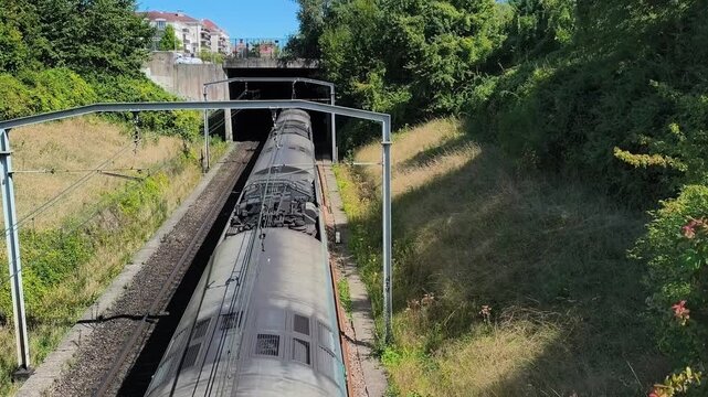 RER A train traveling through green suburbs near Paris, Ile-de-France.