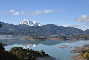 Beautiful landscape of lake and reflection of blue sky, clouds and mountains on surface of lake, Panoramic view of lake and snow-covered mountain and Forest trees calm in Jijel Algeria North African.
