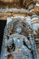 Intricate stone sculpture of a deity at Hoysaleshwara Temple in Halebidu, Karnataka, India, showcasing Hoysala art and detailed carvings