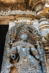 Intricate stone sculpture of a deity at Hoysaleshwara Temple in Halebidu, Karnataka, India, showcasing Hoysala art and detailed carvings