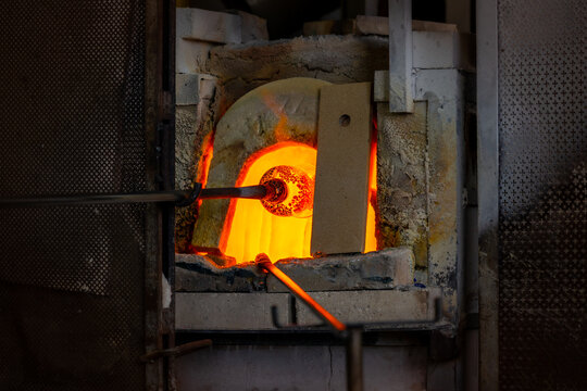 Glass blowing demonstration: melting the glass in the oven during vase creation