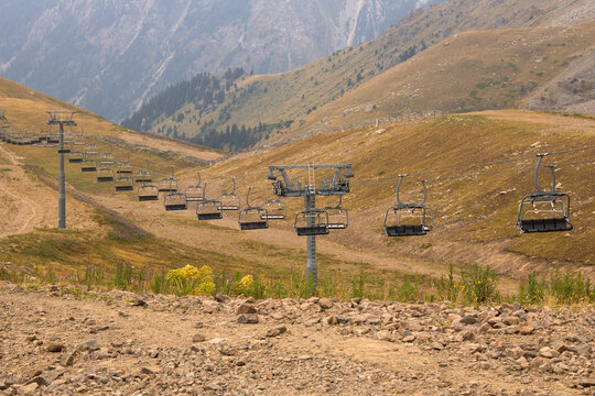 Empty ski lift chairs against rocky mountain landscape