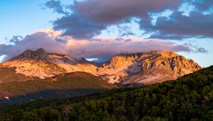 Obraz premium Majestic Mountain Range at Sunset with Dramatic Clouds