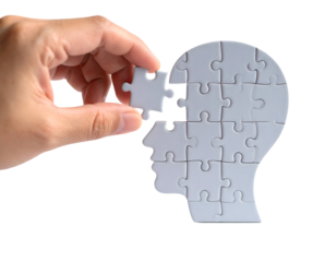 A hand places the final puzzle piece to complete a human head shape, symbolizing thought and understanding.