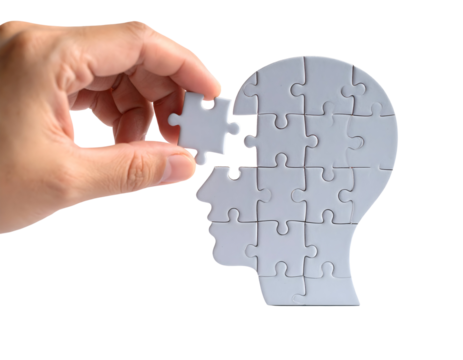 A hand places the final puzzle piece to complete a human head shape, symbolizing thought and understanding.