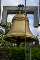Close-up of old golden church bell hanging outdoors with rope