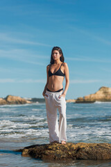 Woman Standing By the Ocean on a rock in Scenic Beach Setting