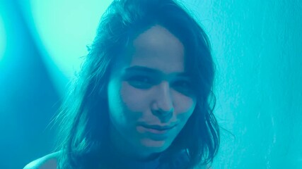 Beautiful young woman is dancing in party. Neon, blue and red light in studio shot, club and music with woman concept. Multicolored skin, ultraviolet light. - Powered by Adobe