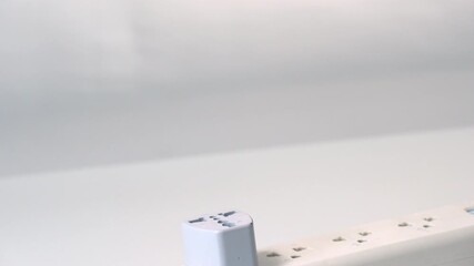 A test plug current with hand holding orange insulated screwdriver tool for electrical safety, power plug adapter, white extension socket, indoor maintenance, caution for electricity testing