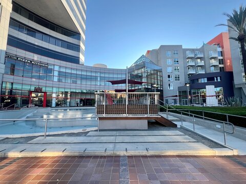 GLENDALE, CA, JUN 29, 2025: contemporary mixed-use development with curved glass building, California Pizza Kitchen storefront, residential apartments, and modern architectural design elements