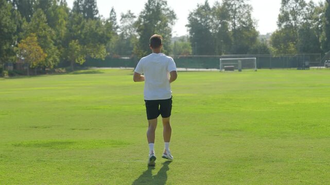 Shirtless Young Man running and doing cardio in Park on Sunny Day