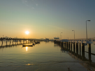 Fototapeta premium aerial view beautiful sunrise cloud above Chalong pier. Sunrise with sweet yellow color light rays and other atmospheric effects. colorful reflection of sunrise in the sea background.