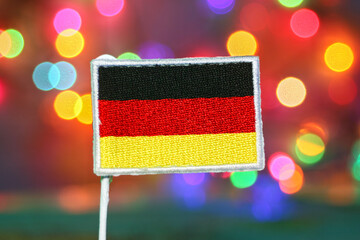 Germany national flag embroidery with colorful festive bokeh lights in the background, symbolizing...