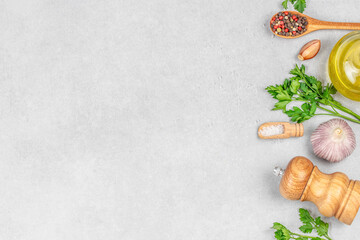 Assorted cooking ingredients with herbs, garlic, and spices on light background, top view. copy space