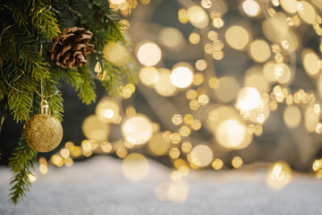 Christmas Holiday background with snow, fir tree and decorations with christmas light behind. Christmas gold and red balls on a winter festive background.