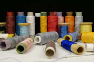 Multicolored spools thread. Spools of multi-colored threads lies on white table