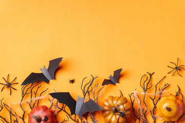Halloween background with black gift boxes, bats, spiders, and webs on an orange backdrop.