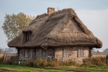 Obraz premium Rustic wooden house with a thatched roof.