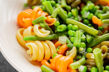 Trottole pasta vegetables green peas, green beans, kohlrabi cabbage, broccoli second course tasty snack fresh delicious gourmet food background on the table rustic food top view copy space