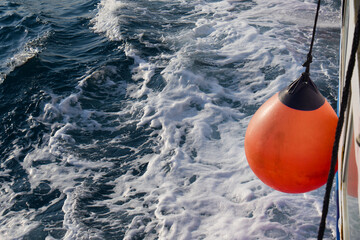 Roter Fender / roter Kugelfender an einem fahrenden Schiff