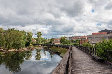 Fototapeta premium Pueblo con puente y vegetación junto a río