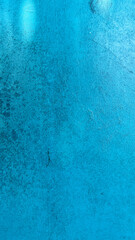 Close-up of a blue painted wall with visible grunge stains and subtle scratches