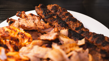 Delicious and healthy mixed grill platter featuring juicy chicken shish, tender lamb shish, and sliced chicken doner kebab. Served on a rustic wooden board. Perfect for food blogs, menus and more.