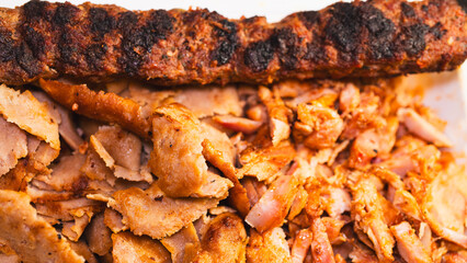 Delicious and healthy mixed grill platter featuring juicy chicken shish, tender lamb shish, and sliced chicken doner kebab. Served on a rustic wooden board. Perfect for food blogs, menus and more.