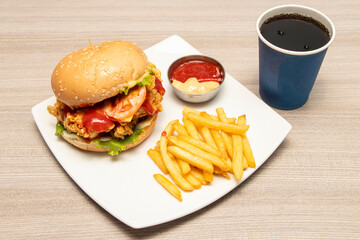 Crispy Chicken Burger with Golden French Fries and a Refreshing Cold Drink in plate side view of bangladeshi food