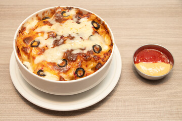 Oven Baked Pasta with Melted Cheese and Olives in bowl side view of bangladeshi food