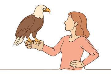 Woman holding a bald eagle on her gloved hand during a nature event outdoors in the afternoon sun