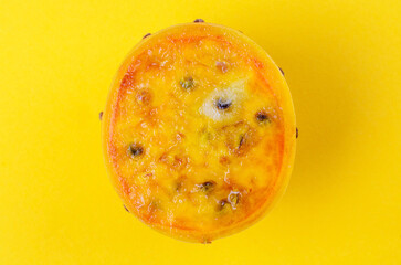 Top view of sliced cactus fruit with orange flesh and dark seeds on yellow background