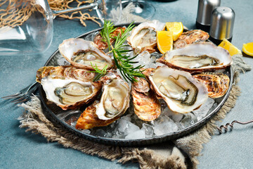 Fresh oysters with lemon on a plate. Healthy seafood. Dinner in restaurant. Gourmet food, side view.