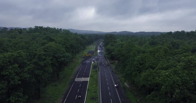 Bhopal, Madhya Pradesh, India, 20 July 2025: Aerial view of the Bhopal-Nagpur Highway captured during the monsoon season. The modern roadway stretches through lush green fields and mist-covered hills.