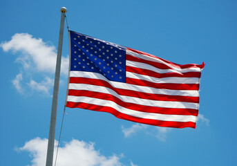 Obraz premium American Flag Waving in a Clear Blue Sky with Wispy Clouds usa flag stars and stripes